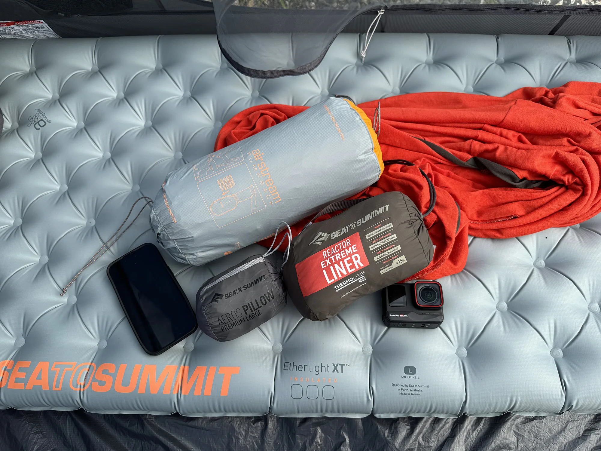 an assortment of sea to summit lightweight camping pads, liner bag, and pillow.