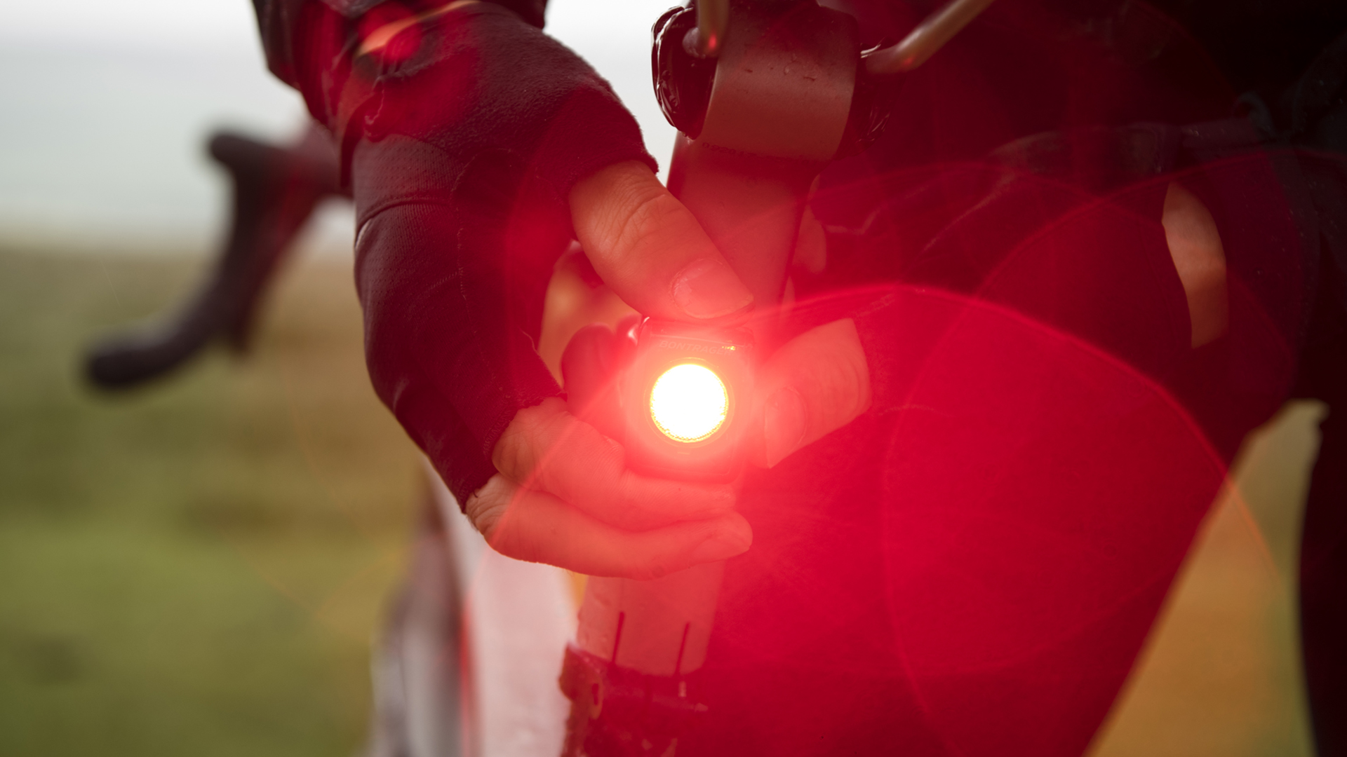 Cyclist attaching a shining rear bike light