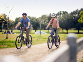 Two riders side-by-side on a bike path.