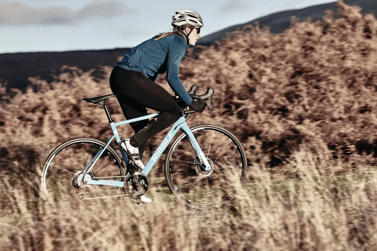 Female cyclist climbing on a road bike in winter Nine tips to conquer the Rapha Festive 500 this year