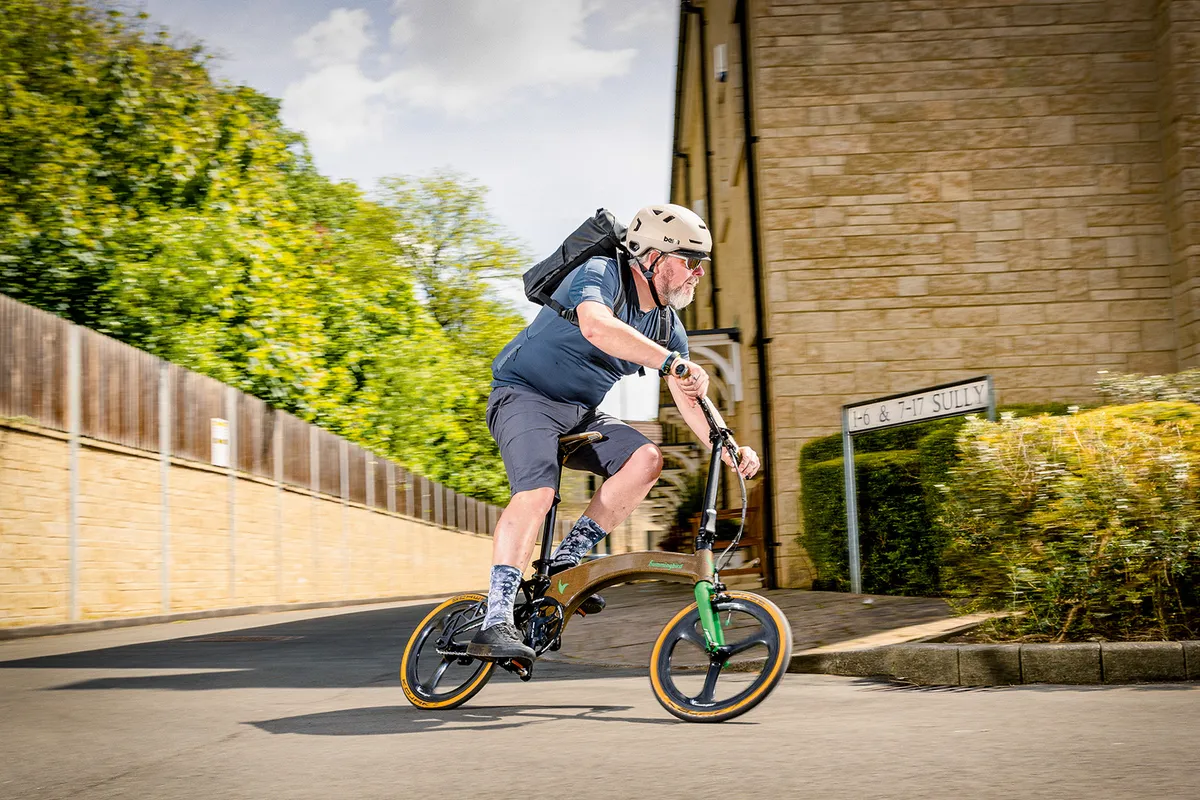 Male cyclist in grey top riding the Hummingbird Single Speed Flax folding bike