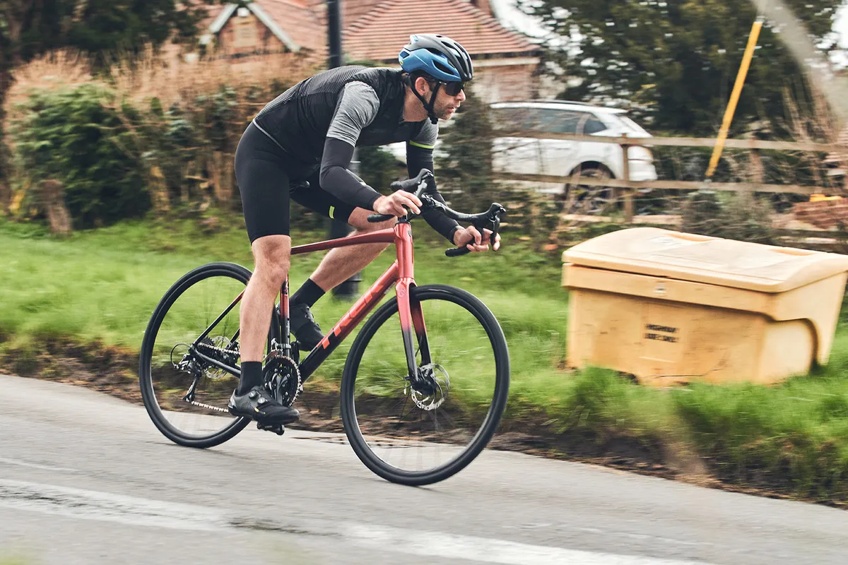 Male cyclist in black top riding the Trek Domane AL 2 Gen 4 road bike