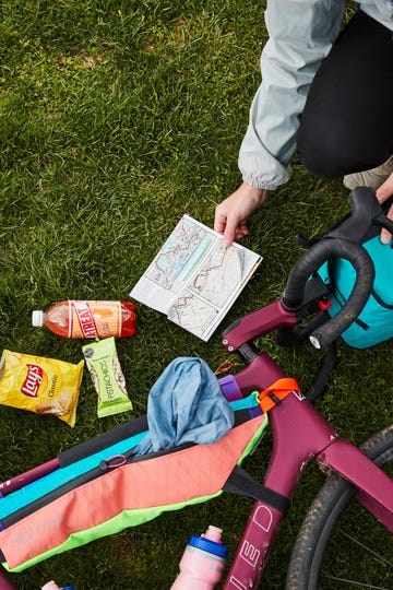 a bike with bags surrounded by some snacks and a map