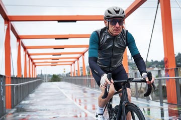 cyclist riding across bridge in rain