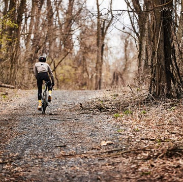 Cyclist riding up a gravel road in cool weather cyclist riding up a gravel road in cool weather