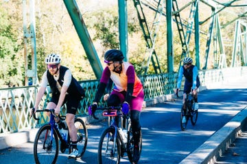 cyclists riding on a bridge during a sunny day