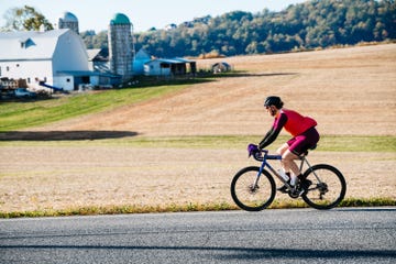 cyclist riding on a rural road near a farm