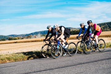 group of cyclists riding on a rural road