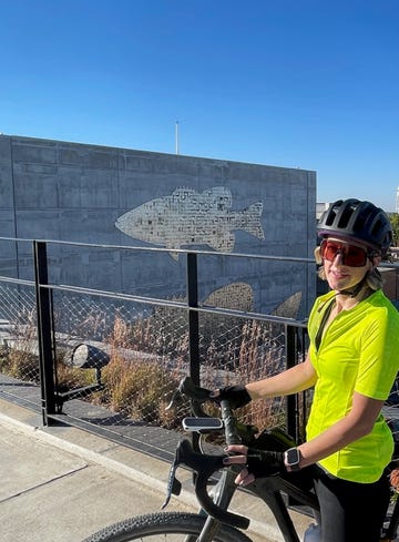 person cycling near a mural featuring a large fish design