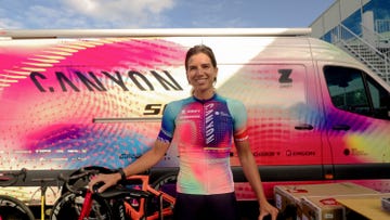 a woman in cycling gear standing in front of a colorful van