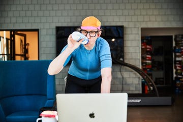 person exercising indoors while holding a drink